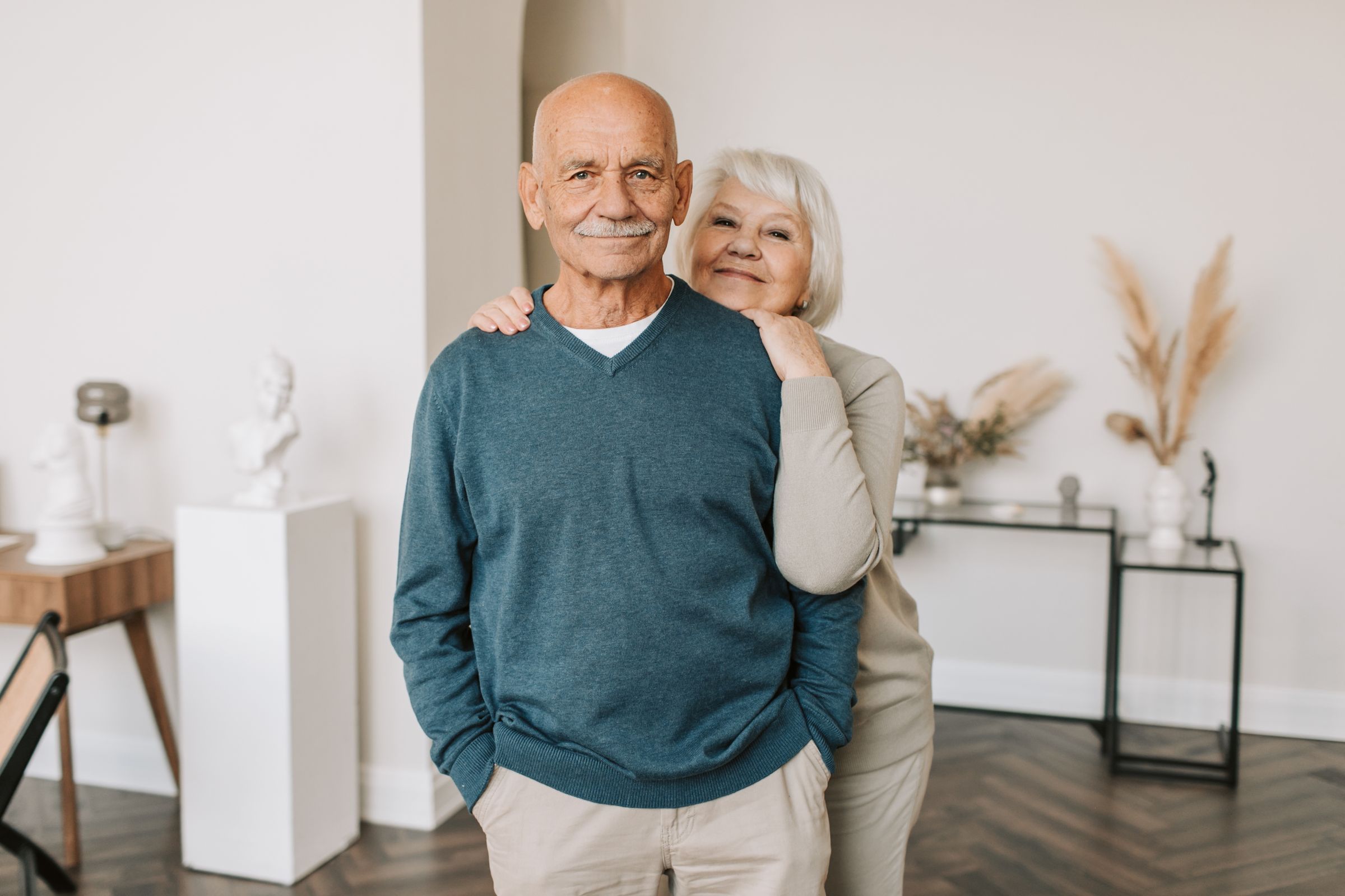 Pareja mayor abrazada y sonriendo a la cámara