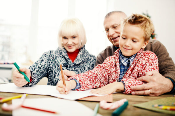 Niño dibujando junto a sus abuelos