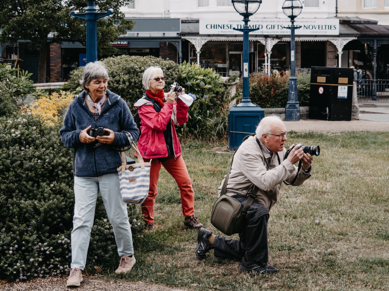 Grupo de personas mayores haciendo fotografías durante una actividad al aire libre