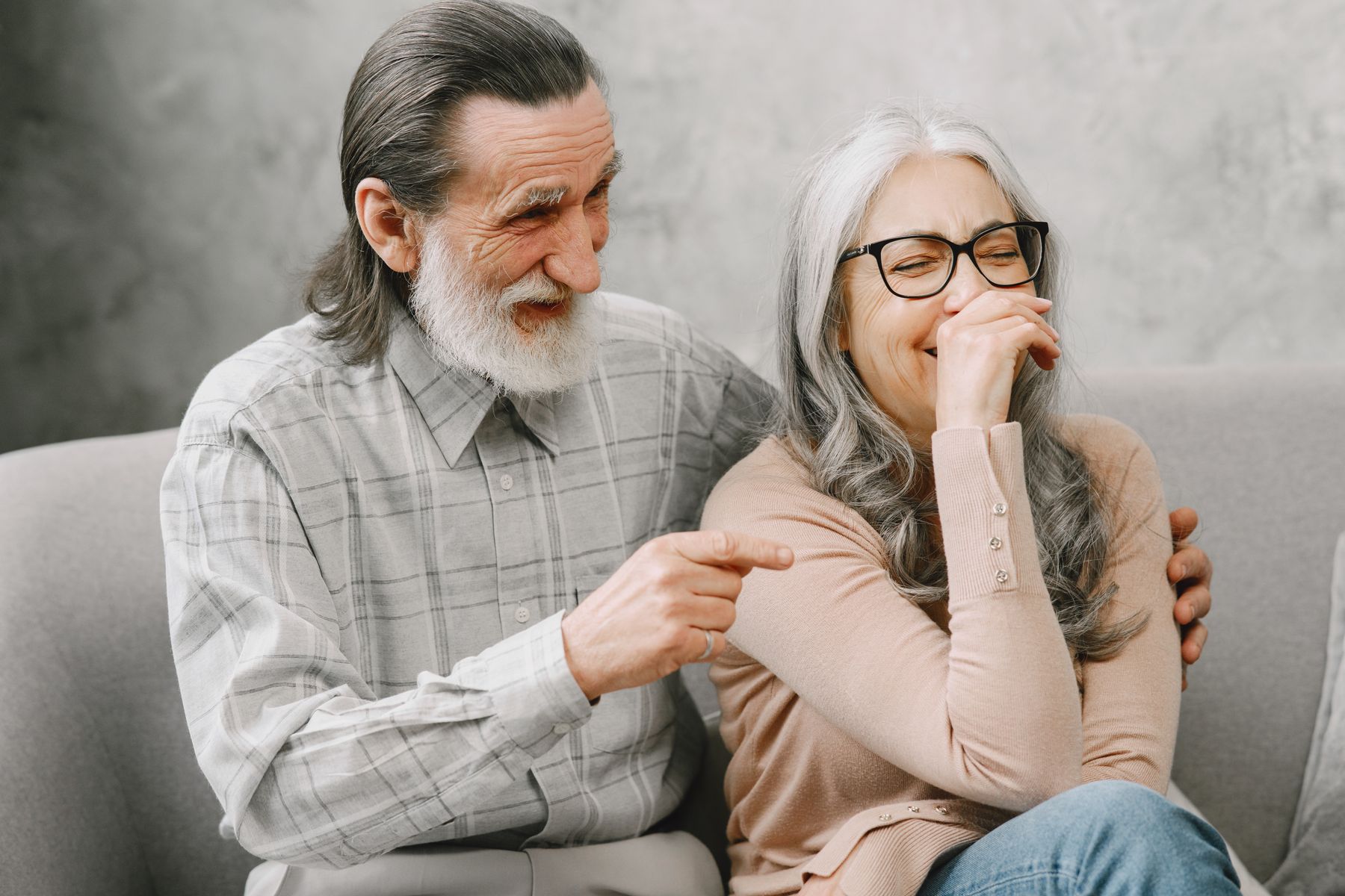 Pareja de personas mayores riendo juntas en casa
